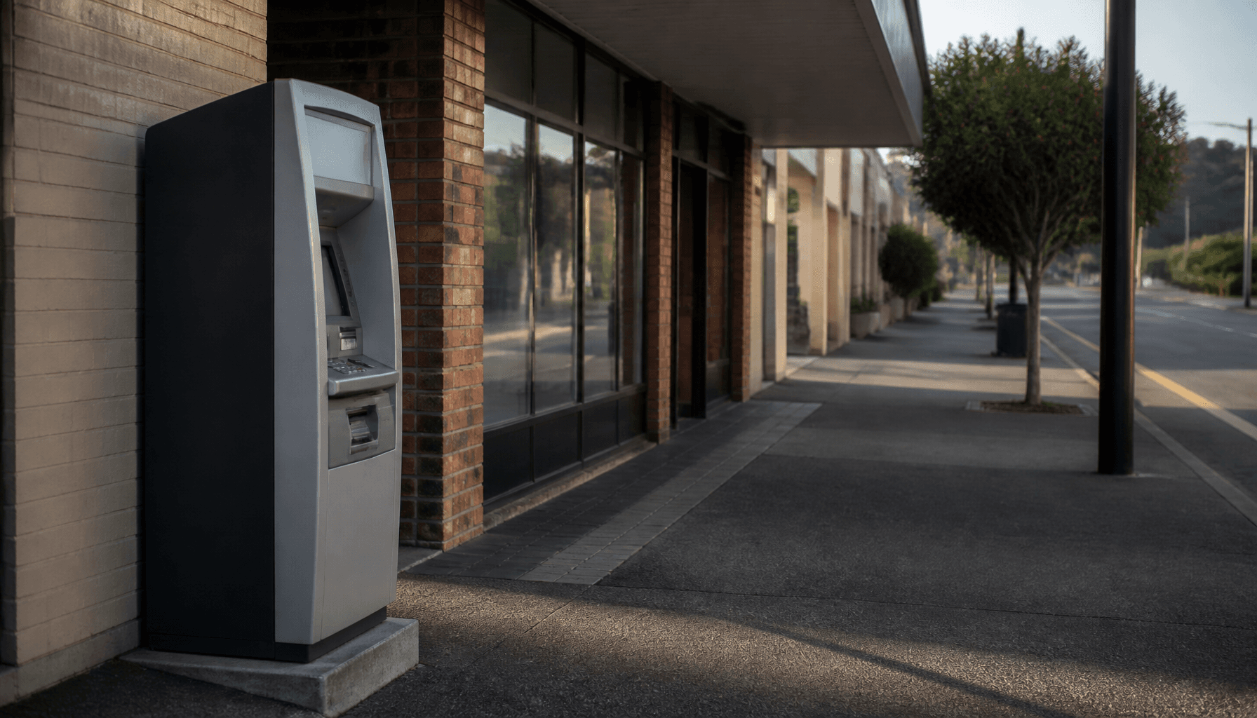 Standalone outdoor cash machine on a quiet New Zealand suburban street
