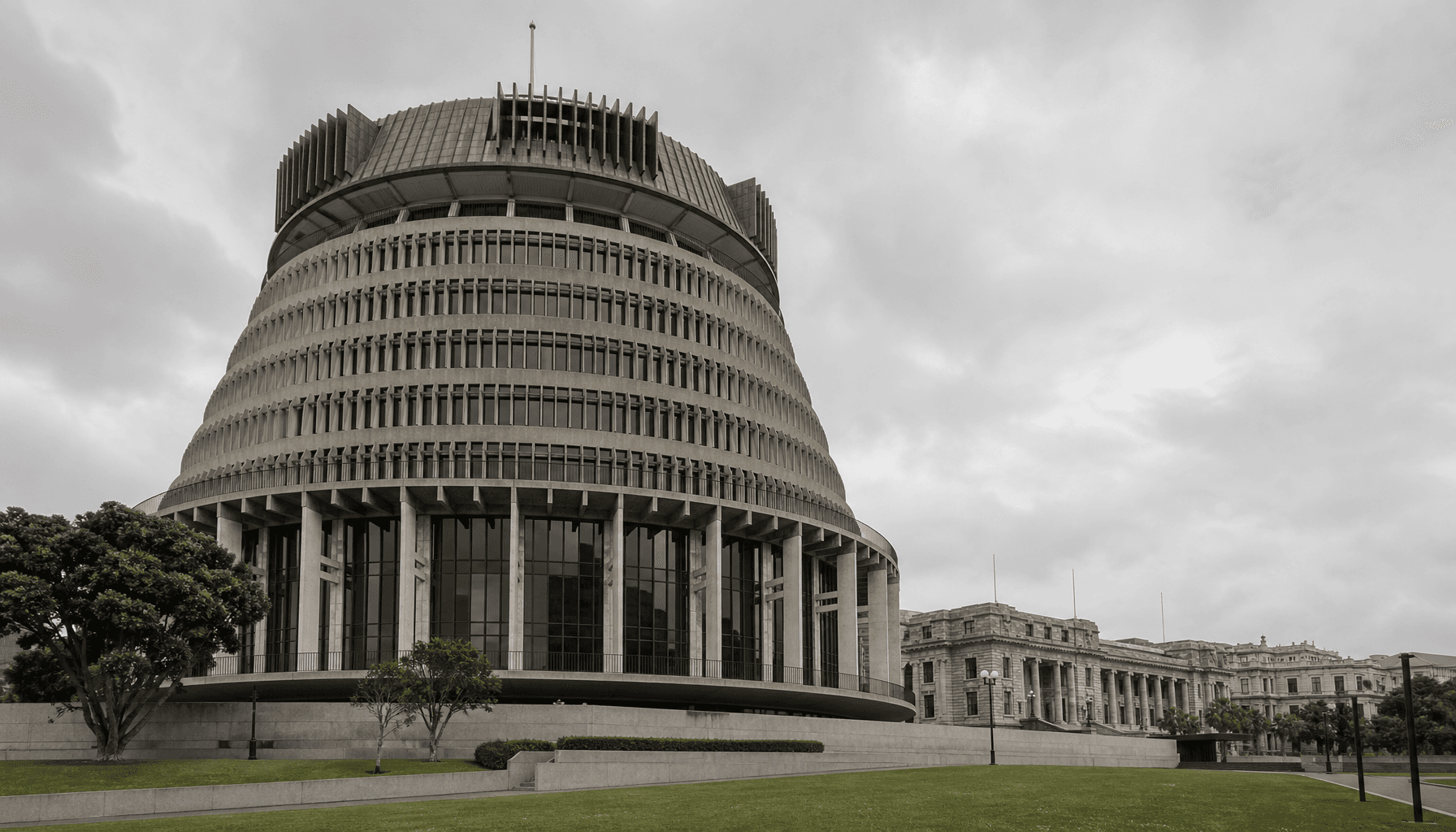The Beehive in Wellington under overcast skies, forecourt empty, conveying constrained government finances.