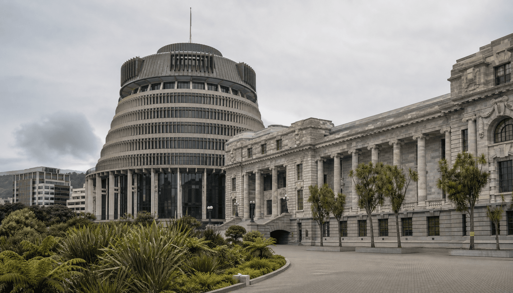 The Beehive and Parliament buildings in Wellington under a pale overcast winter sky, no people visible